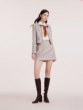 A lady wears a mini skirt and a short jacket.